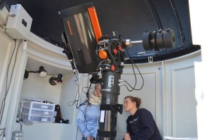 Crew members using the Musk Observatory's telescope.